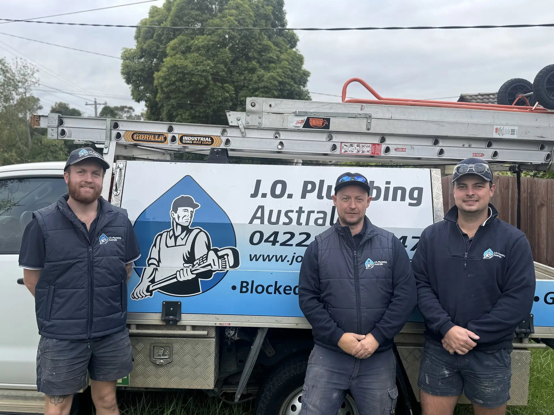 J.O. Plumbing Australia team standing in front of branded work van in Melbourne