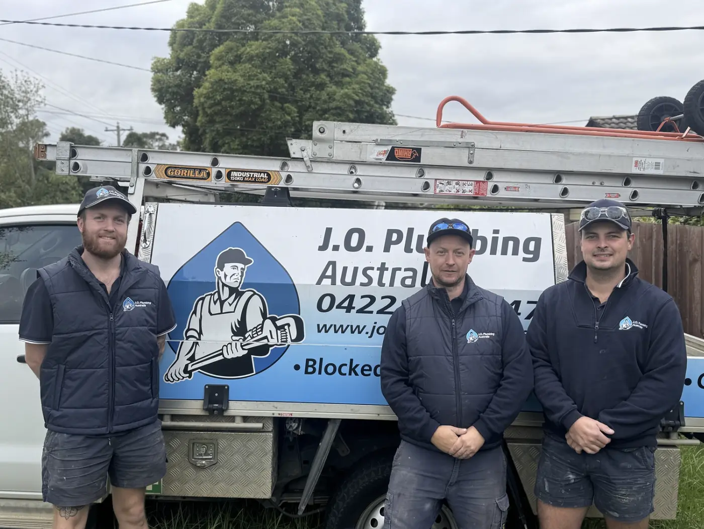 The J.O. Plumbing Australia team standing in front of their branded work van in Melbourne's eastern suburbs